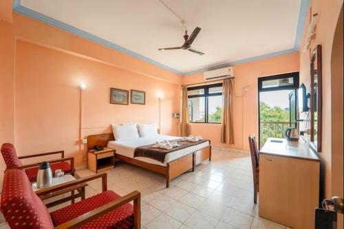 a bedroom with a bed and a couch and a table at Vasco Residency in Vasco Da Gama