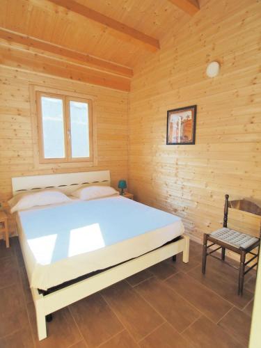 a bedroom with a bed in a wooden room at Agriturismo Paparanza in Valguarnera Caropepe