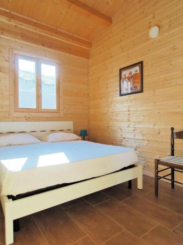 a bedroom with a bed in a wooden room at Agriturismo Paparanza in Valguarnera Caropepe