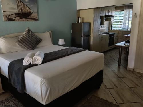 a bedroom with a large bed with towels on it at Ocean House in St Lucia