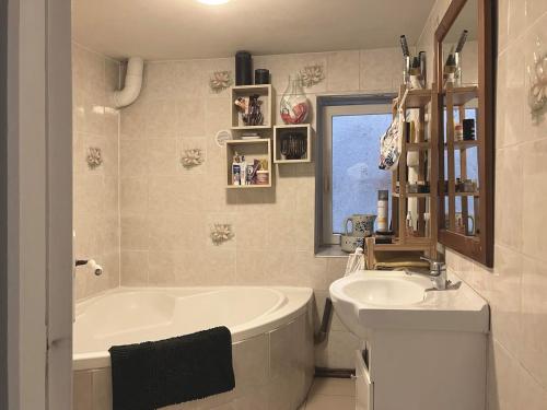 a white bathroom with a tub and a sink at Appartement cosy Rosheim in Rosheim