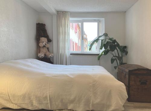a bedroom with a bed with a teddy bear and a window at Appartement cosy Rosheim in Rosheim