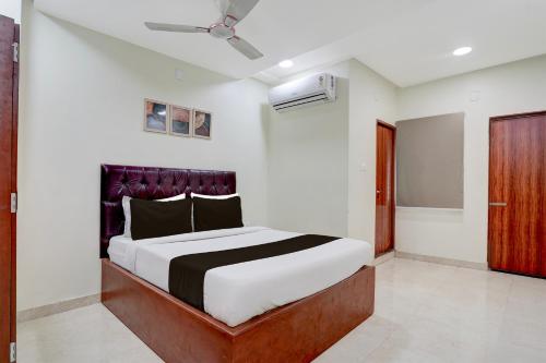 a bedroom with a bed and a ceiling fan at Super Hotel O Magunta Layout Nellore Formerly The Paradise Guest Inn in Nellore