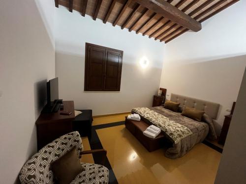 a bedroom with a bed and a desk and a chair at Antico Granaio di LEO Via Antonia 60 in Ponte Pattoli