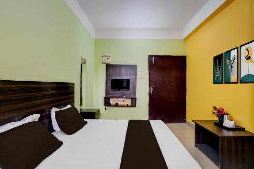 a bedroom with a large bed and a tv at Super Hotel O Sankaradeva Kalakshetra Formerly HK Residency in Dispur