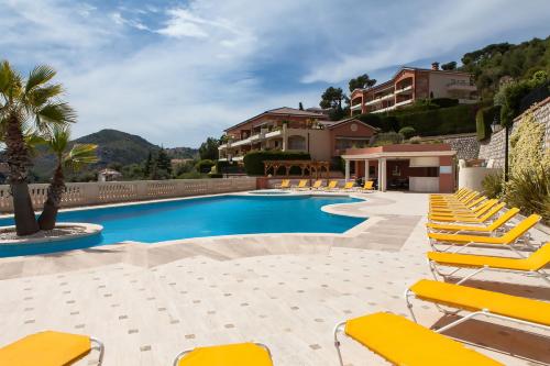 a swimming pool with yellow chairs and a resort at Sunny Panoramic Balcony in Èze