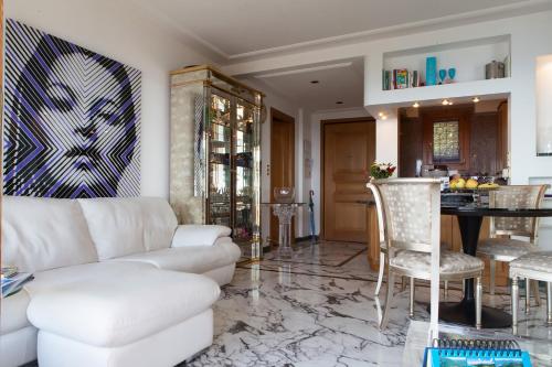 a living room with a white couch and a table at Sunny Panoramic Balcony in Èze