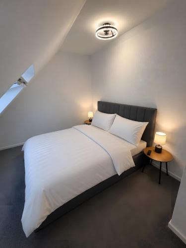 a bedroom with a large white bed with two lamps at Ruheoase Quickborn in Quickborn