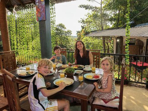 a group of children sitting at a table eating food at Hill Forest Cottage in Ella