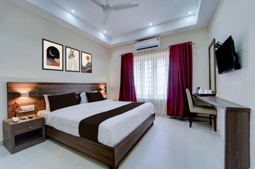a bedroom with a bed and a desk and a computer at Super Collection O RTO Office Uzhavoor Formerly Hotel Zodiac in Puduveli