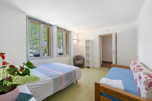 a bedroom with two beds and two windows at L'auberge le Toit Vert in Moutiers