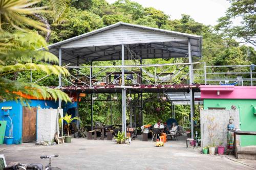 a metal pavilion with people sitting at tables at This is Okinawa Nature Stay Yanbaru Forest in Motobu