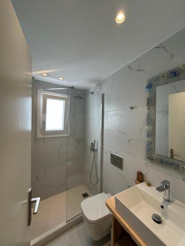 ein Badezimmer mit Dusche, Toilette und Waschbecken in der Unterkunft Hotel Zannet in Parikia