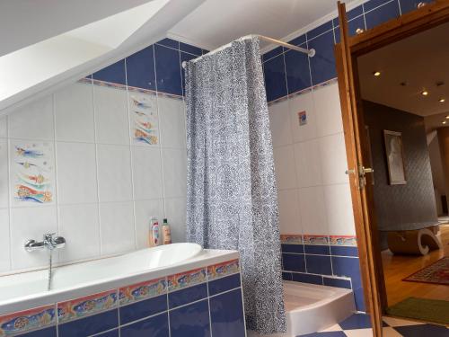 a bathroom with a tub and a shower curtain at Balatonalmádi Pipacs Villa in Balatonalmádi