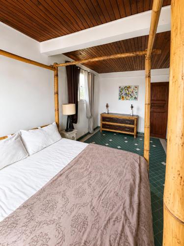 a bedroom with a large bed and a wooden ceiling at La Mansarde in Le Robert