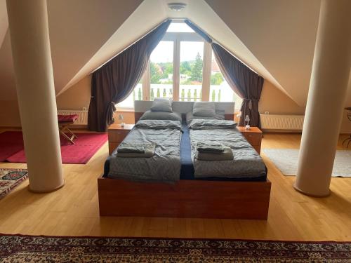 a bedroom with two beds in front of a large window at Balatonalmádi Pipacs Villa in Balatonalmádi