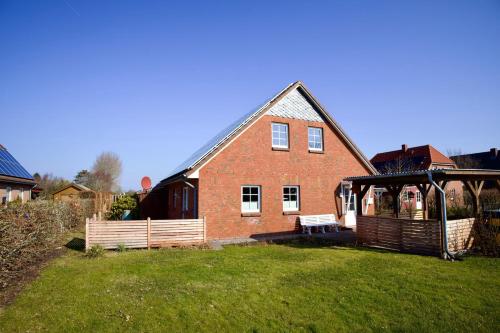 a large brick house with a gazebo in a yard at Hus Utspann in Nordstrand