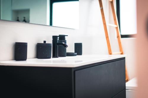 a bathroom counter with a black and white sink at VIVA Quinta I Quinta do Ananás Pineapple Farmhouse in São Roque