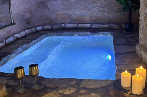 a pool of blue water with candles and lights at Piedra y Luz in Buendía