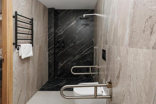 a bathroom with a shower with a black marble wall at Vita Verde in Torrevieja