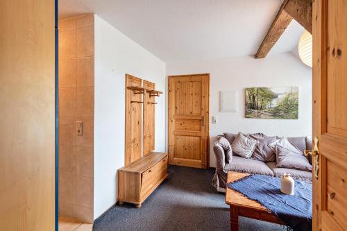 a living room with a couch and a door at Dachstudio Seeblick in Krüselin