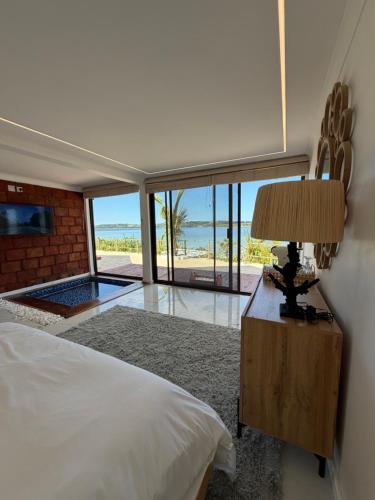 a bedroom with a bed and a table with a lamp at Koko Beach - Honeymoon Suite in Vila Praia Do Bilene