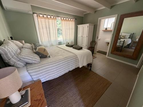 a bedroom with a large bed and a mirror at Hoop Lodge in Bellingen