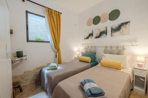a bedroom with two beds and a window at Villa NiLo Natura - Rustic Mountain Charm in Telti