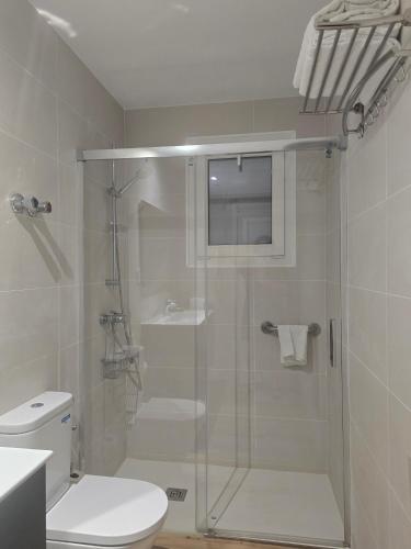 ein Badezimmer mit Glasdusche und WC in der Unterkunft Hotel Grifeu y Restaurant - Costa Brava in Llança