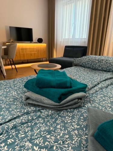 a bedroom with a bed with green towels on it at Apartament Bursztynowy Lębork in Lębork