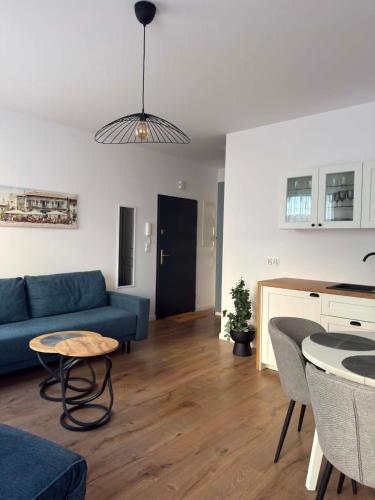 a living room with a blue couch and a table at Apartament Bursztynowy Lębork in Lębork