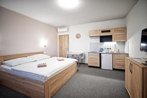 a bedroom with a large bed and a kitchen at U Jeřába - komplex C in Horní Věstonice
