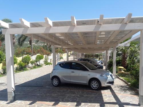 a small car parked under a white pergola at Cruccùris Resort - Adults Only in Villasimius