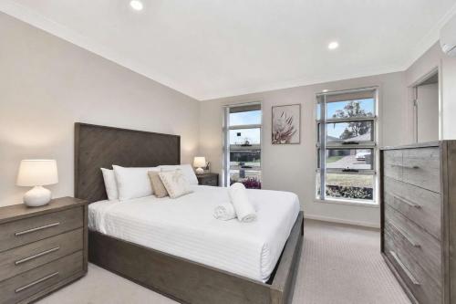 a bedroom with a large bed and two windows at Hunter Hideaway in Cessnock