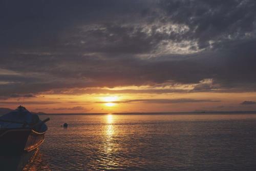 a boat on the water with a sunset in the background at Rin Bay View Resort in Haad Rin
