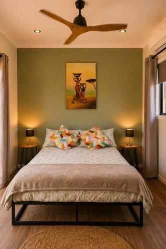a bedroom with a bed with a ceiling fan at Sunshine cottage in Clontarf
