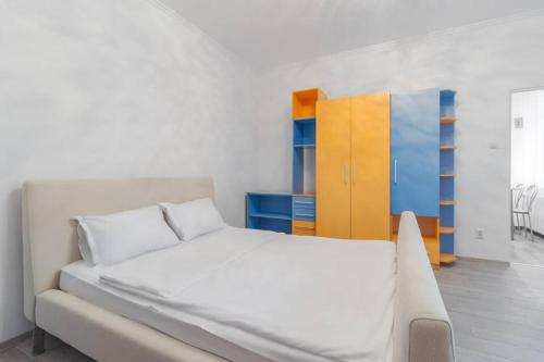 a bedroom with a white bed and a colorful cabinet at Azure Wave - Ultra Central in Oradea
