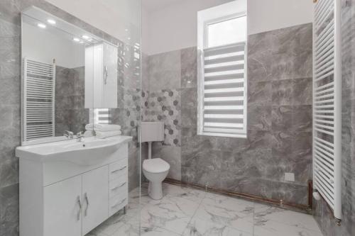 a white bathroom with a sink and a toilet at Azure Wave - Ultra Central in Oradea