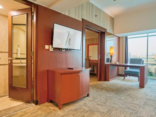 a hotel room with a television on a wall at Horison Ultima Menteng Jakarta in Jakarta