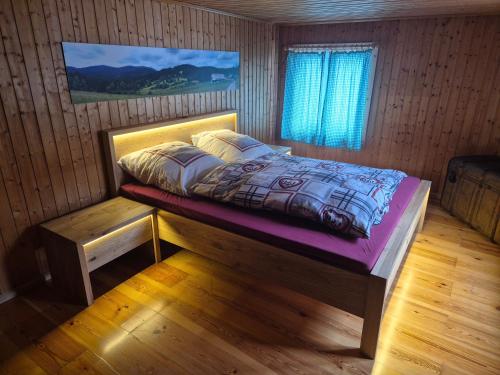 a bedroom with a bed in a wooden room at Zum fröhlichen Eichhörnchen in Feldberg