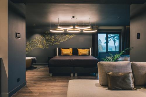 ein Schlafzimmer mit einem Bett und einem Kronleuchter in der Unterkunft Hotel Papendal in Arnhem