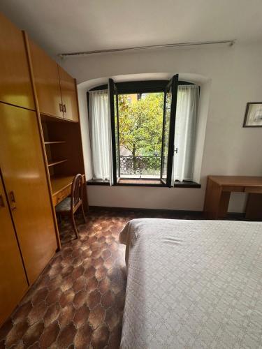 a bedroom with a bed and a window and a desk at Villa Elisabetta in Malcesine
