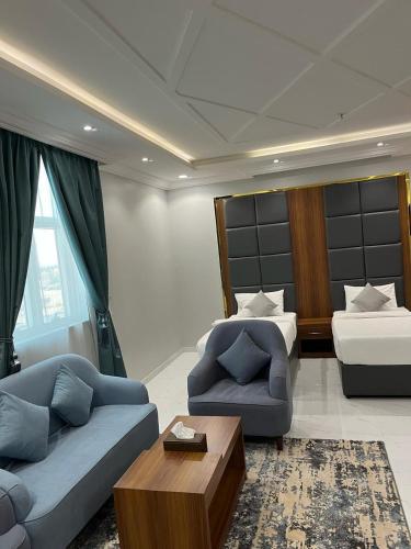 a living room with a couch and a bed at شقق وجهة الوصول in Ar Rawshān