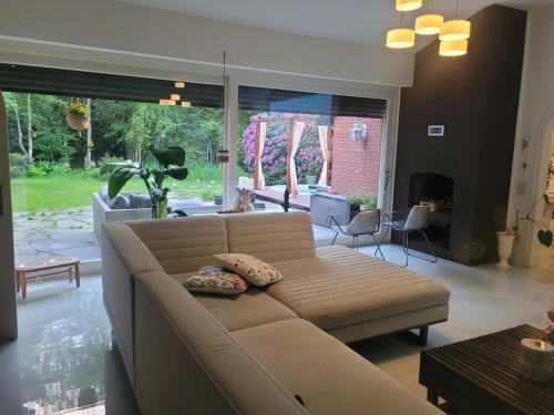 a living room with a couch and a large window at Natur Spa Haus in Niederkrüchten