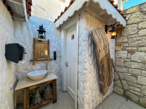 a bathroom with a sink next to a stone wall at Filizce Alaçatı in İzmir