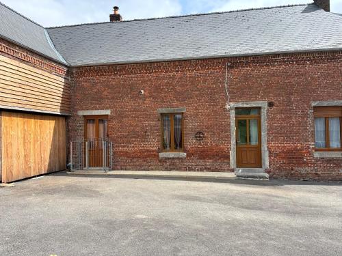 a brick building with a gate and a garage at Country house in Erloy, Oise valley in Erloy