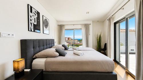 a bedroom with a large bed with a large window at Villa Santa Rosa - Conforto e lazer com piscina e zona de jogos em Armação de Pêra in Armação de Pêra