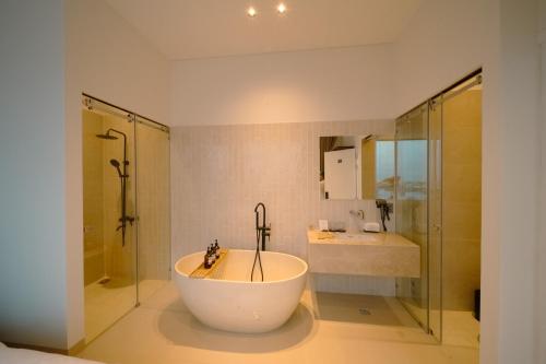 a bathroom with a tub and a shower and a sink at ANNA Boutique Villa - Sea View in Phan Thiet