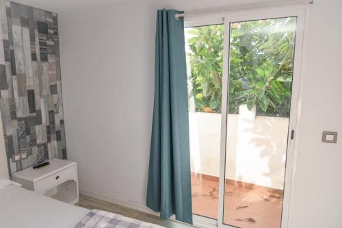 a bedroom with a sliding glass door with a window at Home D'or in Cala d´Or