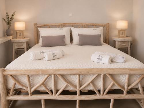 a large bed with two pillows on it at Aenia Suites in Foinikiá